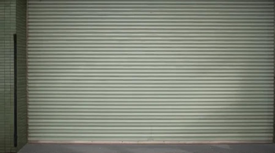 Porta de aço de enrolar em garagem, obra da PW Vidros em São Paulo
